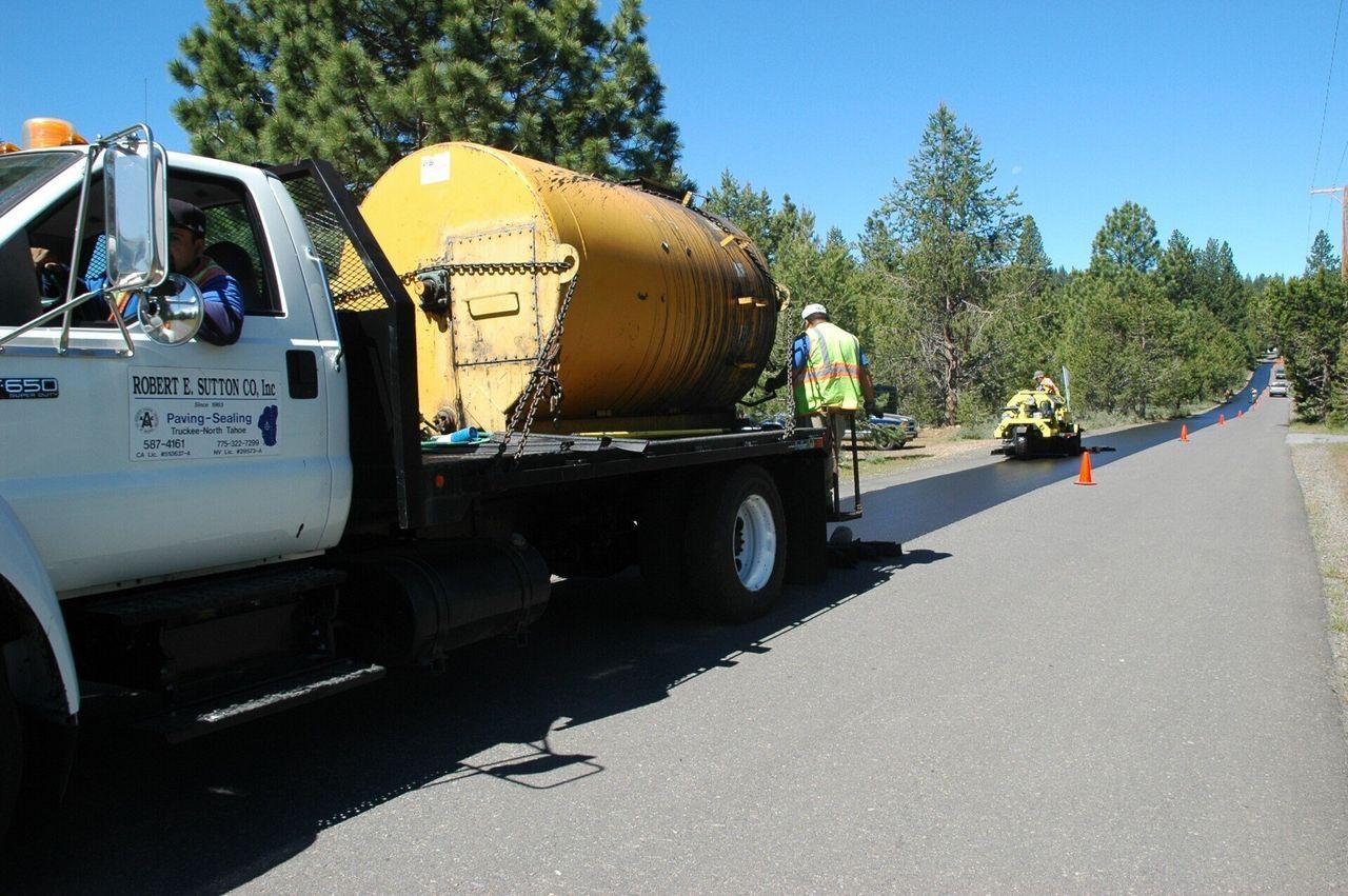 Sutton Co. tank truck sealcoating a road in the Tahoe Donner area with the crew.