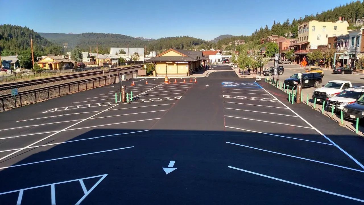 The freshly sealed and striped downtown Truckee depot lot, mountains behind.
