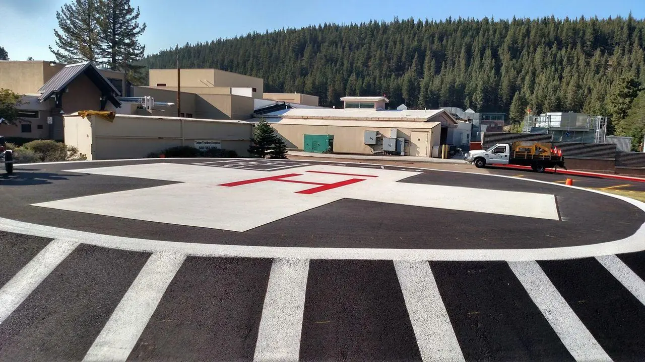 A freshly striped hospital helipad in Truckee with a red H on white cross markings.